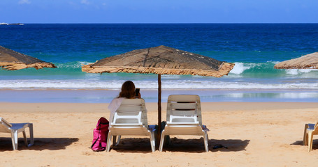 woman on deck chair on a paradise beach