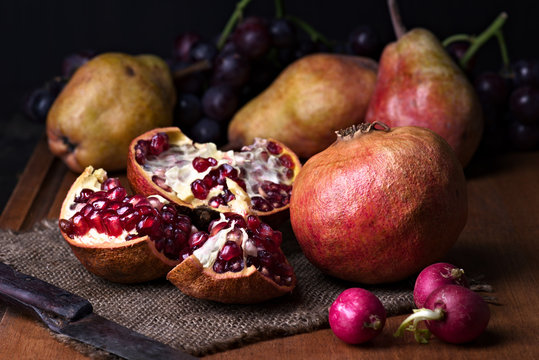 pomegranates and pears with other fruit bodegon with classic light on wood