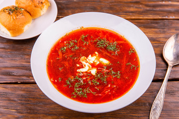A plate of borsch with sour cream and greens