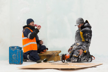 Obraz premium Worker on a sheet of plywood repairing gasoline saw