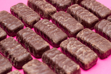 a lot of chocolates on a pink background, the background of chocolates,dessert
