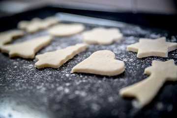 Biscuits of different shapes are lying on the tram and ready for baking.
