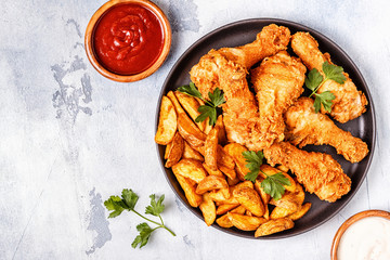 Fried chicken legs with potatoes.