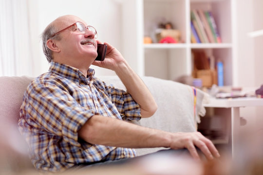 Excited senior man father or grnadfather talking on the phon