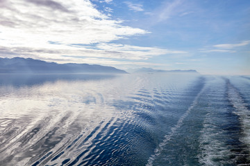 Wake Of Boat On Lake In Alaska Surrounded By Mountains And Forests