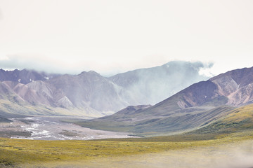 Dry River Bed Running Through Valley Between Mountains In Alaska