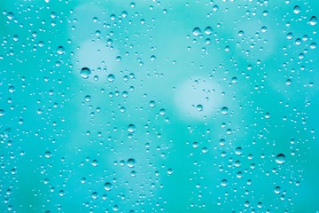 closeup drops water on blue glass background