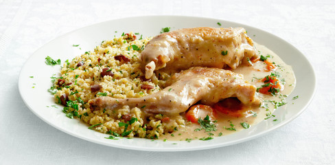 rabbit legs stewed with apricots and white vine garnished with parsley and kalamata olives wheat