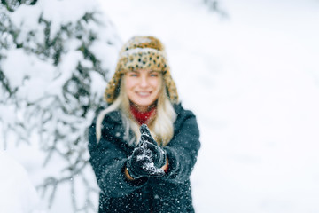 girl in a fashionable winter hat with a leopard print rejoices in the snow