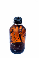 Close up of a bottle shaped kerosene lamp or oil lantern isolated on white burning.