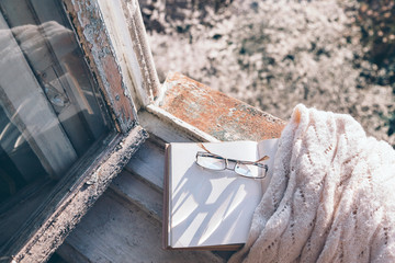 Book and coffee on window sill over spring tree