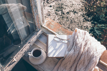 Book and coffee on window sill over spring tree