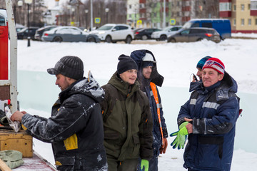 Fototapeta premium Workers on the installation of the ice town