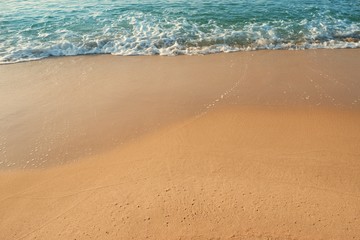 Sand beach with blue waves ocean.