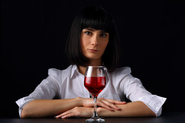 Portrait of a young woman with a glass of red wine