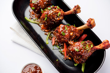 Szechuan Chicken which is a popular Indo-Chinese non vegetarian recipe. served in a plate with chilli sauce. selective focus