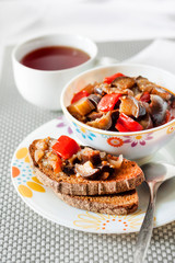 Vegetable stew with eggplant, red pepper and tomatoes on toasted rye bread