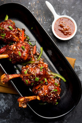 Szechuan Chicken which is a popular Indo-Chinese non vegetarian recipe. served in a plate with chilli sauce. selective focus