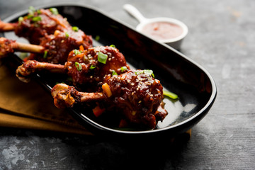 Szechuan Chicken which is a popular Indo-Chinese non vegetarian recipe. served in a plate with chilli sauce. selective focus