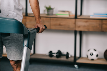 cropped view of man exercising on treadmill