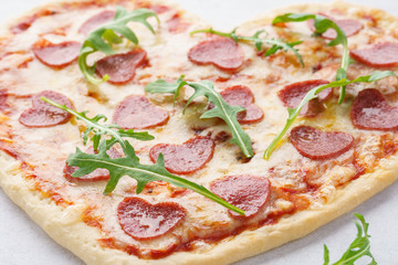 Close-up shot of heart shaped pizza with pepperoni.