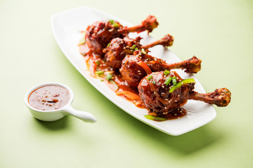 Szechuan Chicken which is a popular Indo-Chinese non vegetarian recipe. served in a plate with chilli sauce. selective focus