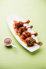 Szechuan Chicken which is a popular Indo-Chinese non vegetarian recipe. served in a plate with chilli sauce. selective focus