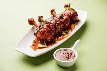 Szechuan Chicken which is a popular Indo-Chinese non vegetarian recipe. served in a plate with chilli sauce. selective focus