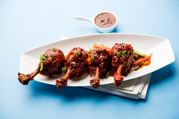 Szechuan Chicken which is a popular Indo-Chinese non vegetarian recipe. served in a plate with chilli sauce. selective focus