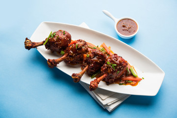 Szechuan Chicken which is a popular Indo-Chinese non vegetarian recipe. served in a plate with chilli sauce. selective focus