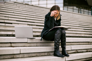 Tired businesswoman having working outdoor.