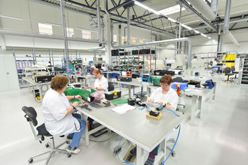 Fototapeta na wymiar Assembly of electronics in a factory - women at work // Montage von Elektronik in einer Fabrik - Frauen am Arbeitsplatz
