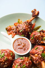 Szechuan Chicken which is a popular Indo-Chinese non vegetarian recipe. served in a plate with chilli sauce. selective focus