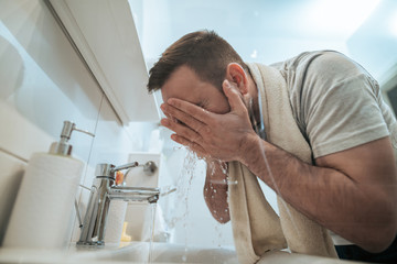 Man washing his face in morning, low angle image.