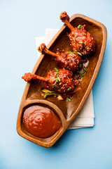 Szechuan Chicken which is a popular Indo-Chinese non vegetarian recipe. served in a plate with chilli sauce. selective focus