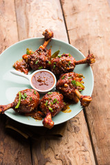 Szechuan Chicken which is a popular Indo-Chinese non vegetarian recipe. served in a plate with chilli sauce. selective focus