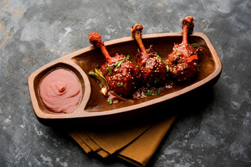 Szechuan Chicken which is a popular Indo-Chinese non vegetarian recipe. served in a plate with chilli sauce. selective focus