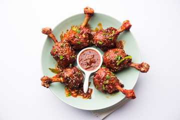 Szechuan Chicken which is a popular Indo-Chinese non vegetarian recipe. served in a plate with chilli sauce. selective focus © Arundhati