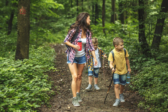 Mother and her little sons hiking trough forest.Spring concept.