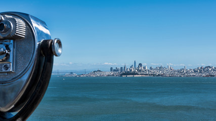 Popular observation point by the northern side of Golden Gate bridge, with cropped binoculars on the left, offering stunning vistas of the bay and the skyline of San Francisco city, California, USA
