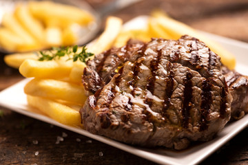 Grilled beef steak on wooden cutting board