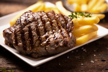 Grilled beef steak on wooden cutting board