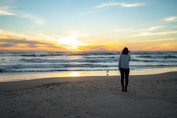 Sad girl on the beach with her phone on her hand