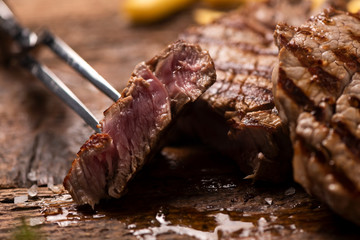 Grilled beef steak on wooden cutting board