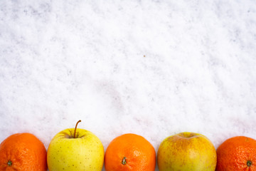 Fruits on the snow, mandarines, apples, pear