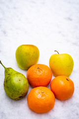 Fruits on the snow, mandarines, apples, pear