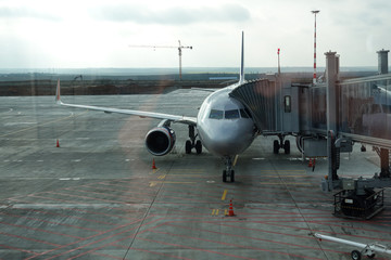 The front side of the aircraft and an enclosed gangway approaches the aircraft for loading...