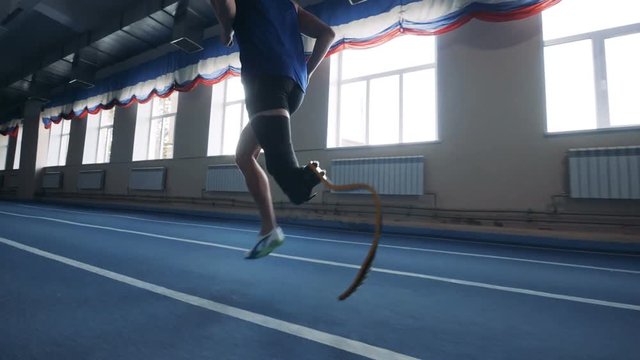 One man running with prosthetic leg, side view.