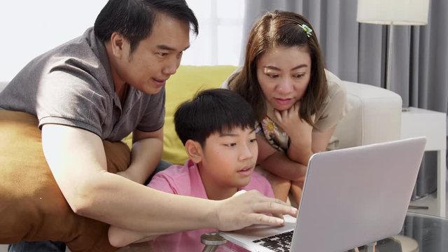 4K Family lifestyle is playing computer games. Asian Mother father and son watching on laptop computer with smile face.