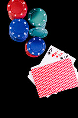 chips and playing cards in a poker play on green and black background